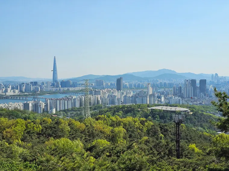 아차산 숲 너머로 보이는 한강과 서울 동부 도심