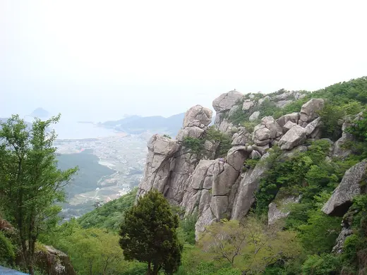 금산 푸른 산림과 암봉 너머로 보이는 남해 바다
